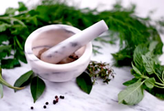 Pestle and mortar next to some herbs